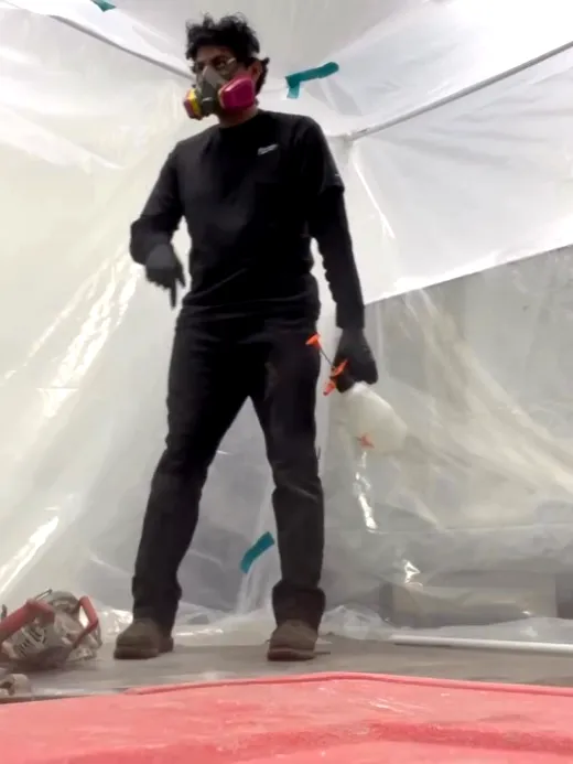 A commercial kitchen sealed off floor to ceiling in plastic containment sheeting