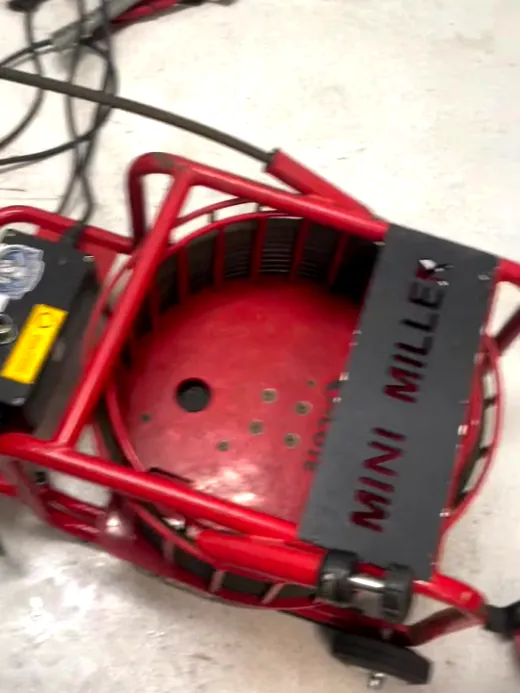 A red drum drain machine set down on the floor of a retail unit