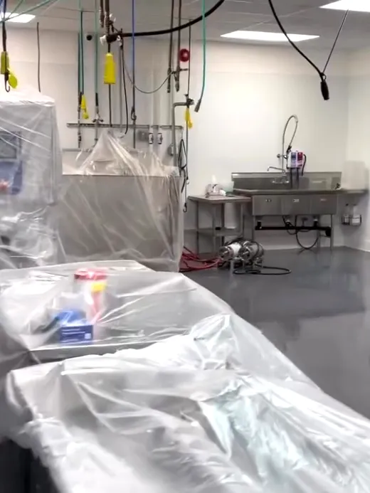A commercial kitchen with its benches and equipment sheeted over in plastic